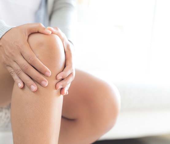 Patientin umfasst ihr schmerzhaftes Knie